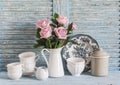 Pink roses in a white enameled pitcher, vintage crockery on blue wooden rustic background. Kitchen still life in vintage style. Royalty Free Stock Photo