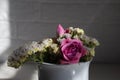 Pink roses, white roses and white limonium in a vase.