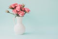 Pink roses in white vase on light blue background Royalty Free Stock Photo