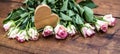 Pink roses and wooden heart on rustic wooden table - Flower background vintage Royalty Free Stock Photo