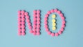 Pink round pills forming the word NO