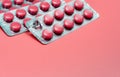 Pink round tablets pills in blister pack on pink background. Painkiller medicine. Take pill. Pharmacy product package.