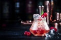 Pink rum alcoholic cocktail drink with white rum, pineapple juice, cranberries, raspberries and ice. Black bar counter background Royalty Free Stock Photo