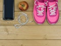Pink running shoes for fitness classes at the gym and a Apple on wooden floor. View from above. Royalty Free Stock Photo