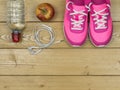 Pink running shoes for fitness classes at the gym and a ripe Apple on a floor. View from above. Royalty Free Stock Photo