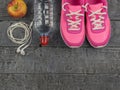 Beautiful pink sneakers, headphones, water and apples on a wooden floor. View from above. Royalty Free Stock Photo