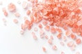 Pink salt crystals scattered loosely on a clean, solid white background