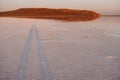 Pink salt lake at sunset. Shadow silhouette of a couple in love on background of the lake. Water surface reflects the Royalty Free Stock Photo
