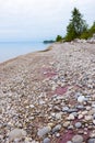 Pink sand and stones on the lake shore on a summer day.