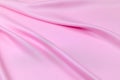 Pink saturated fabric is laid by diagonal soft folds