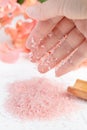 Pink sea salt dripping on a woman`s hand Royalty Free Stock Photo