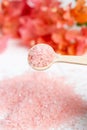 Pink sea salt dripping from a wooden spoon Royalty Free Stock Photo