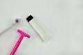 Pink shaving stick, removable toothbrush head and white tube with cream or toothpaste on light background with shadows. Woman Royalty Free Stock Photo