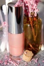 Pink shiny lip gloss jar with other cosmetics jars on the makeup desk