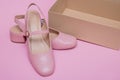 pink shoes with empty shoebox on pink background