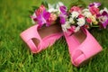 Pink shoes with pink bouquet on the grass, wedding day. Royalty Free Stock Photo