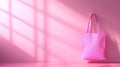 A pink shopping bag hangs on a pink wall with window shadows in a studio setting space Royalty Free Stock Photo