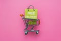 Pink shopping cart on background, shop online, free delivery concept