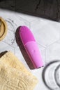 Pink silicone brush, face washing device. Beauty device. Deep cleanser and massager on bright tile background