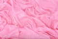 The pink silk fabric lies in folds in the water