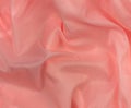 Pink silk fabric texture top view. Red coral glossy satin background. Fashion color feminine clothes trend Royalty Free Stock Photo