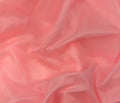 Pink silk fabric texture top view. Red coral glossy satin background. Fashion color feminine clothes trend Royalty Free Stock Photo