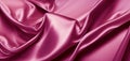 Pink silk satin fabric background. Wavy soft folds of pink fabric. Shiny fabric surface