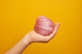 Pink slime with sequins, in a child`s hand, on a yellow background.Creativity, creativity and experiments. Homemade with