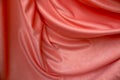 Pink smooth fabric in large folds and tints as a backdrop. Pastel color texture