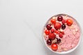 Pink smoothie bowl with fresh berries, nuts and seeds on white marble table. healthy breakfast. top view Royalty Free Stock Photo