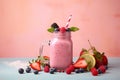 Pink smoothie surrounded by berry fruits