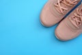 Pink sneakers on a blue background top view.