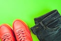 Pink sneakers and jeans on green background. Concept of sport and healthy lifestyle.