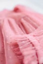 Pink soft tulle polka dot or tulle with flies, texture background. Long sleeve and lined tulle dress for girl, fabric folds waves