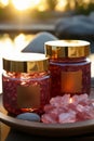 Pink spa salt crystals, jars of pink bath oil beads, against a summer sunset backdrop, exuding luxury and tranquility Royalty Free Stock Photo