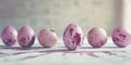 Pink speckled eggs arranged in a row on a textured surface Royalty Free Stock Photo