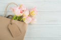 Pink spring tulips in bag with blank tag Royalty Free Stock Photo