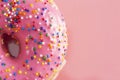 A Pink Sprinkle Donuts on a Pink Background