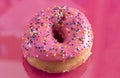 A Pink Sprinkle Donuts on a Pink Background