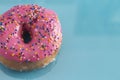 A Pink Sprinkle Donuts on a Turquoise Background