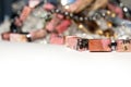 Pink square beads. Red-brown stone on the foreground. Jewels on the white background