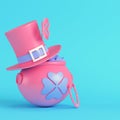 Pink St. Patrick`s day pot of gold with top hat and horse shoe on bright blue background in pastel colors