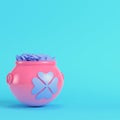 Pink St. Patricks pot of golden coins with clover leaves in the front on bright blue background in pastel colors. Minimalism