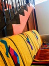 Pink stairway over colorful couch with Mexican turtle blanket iron wrought stairway