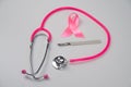 Pink stethophonendoscope, satin ribbon and scalpel on white background. Royalty Free Stock Photo