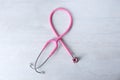 Pink stethoscope as awareness ribbon on light background, top view. Royalty Free Stock Photo