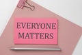 Pink sticker on pink paper with pencil on a white background with text EVERYONE MATTERS Royalty Free Stock Photo