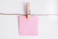 Pink stickers on clothesline with wooden clothespin isolated on white background. Place for your text Royalty Free Stock Photo