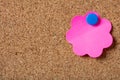 Pink sticky single note with blue pushpin and blank space, isolated on cork background. Royalty Free Stock Photo