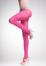 Pink stockings on woman legs on grey